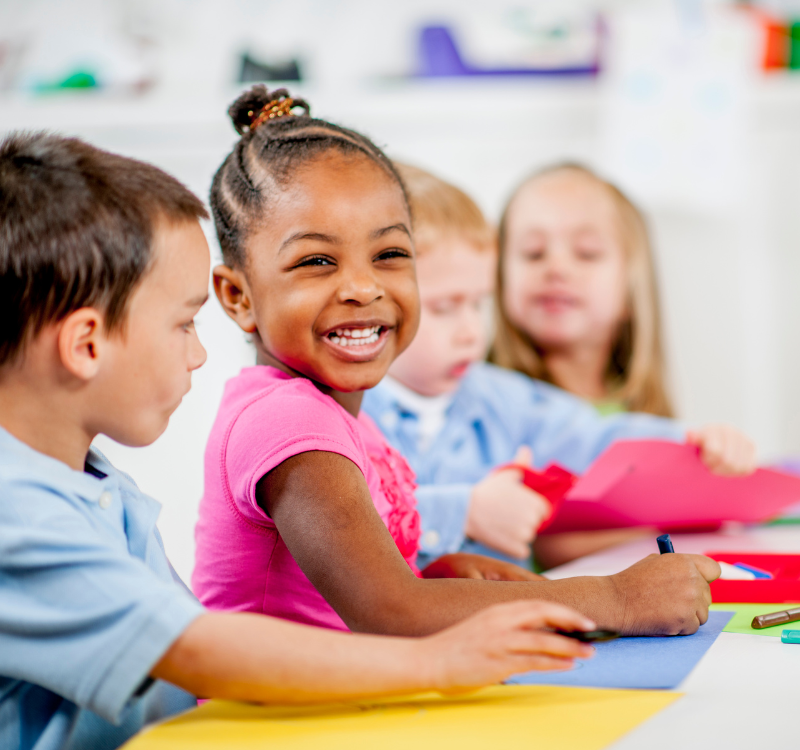 Young girl smiling while colouring