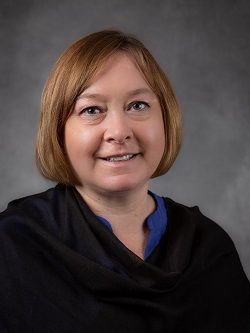 Councillor Bernia Martin, with chin length light auburn coloured hair, wearing a black scarf and royal blue coloured top