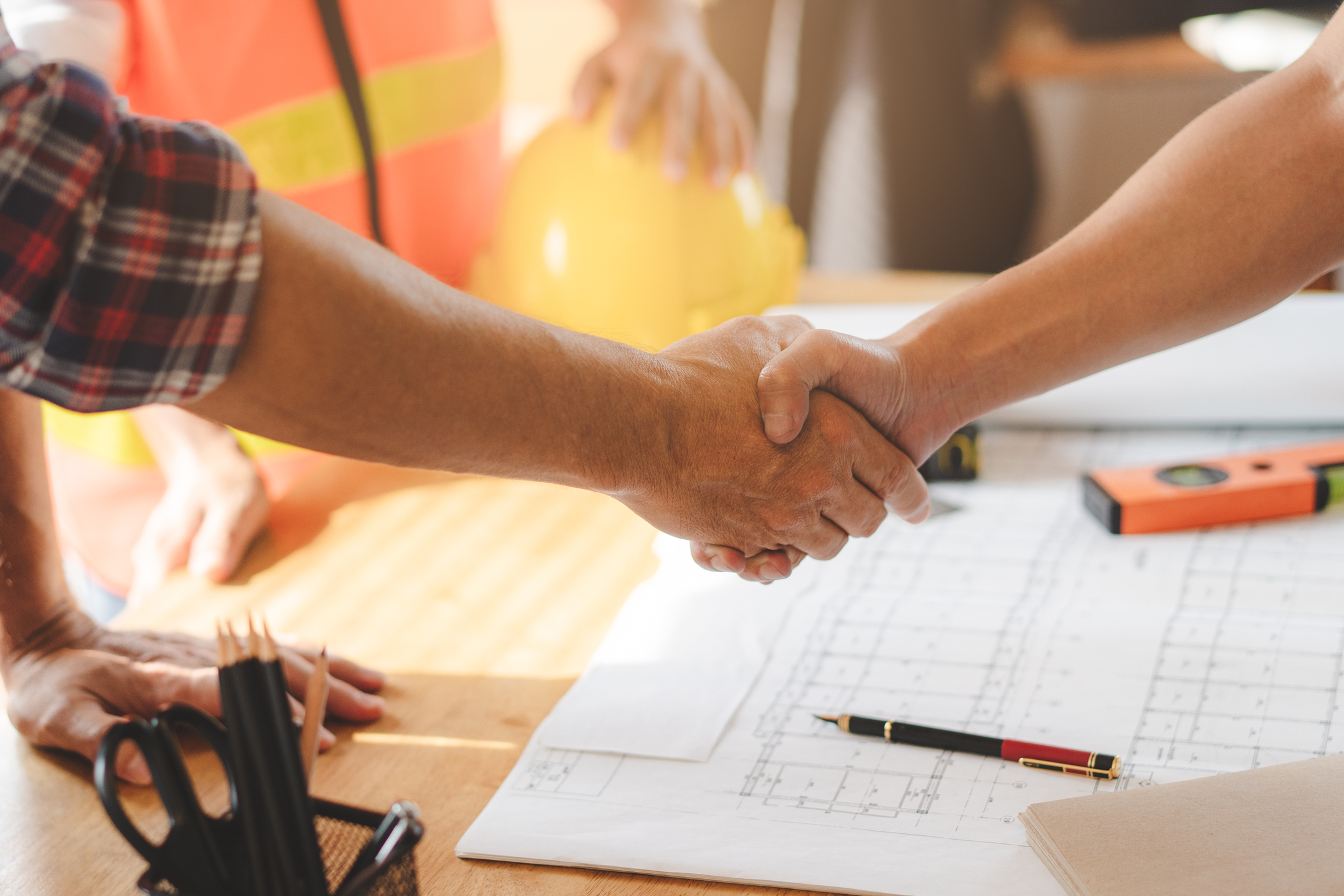 Handshake over building plans
